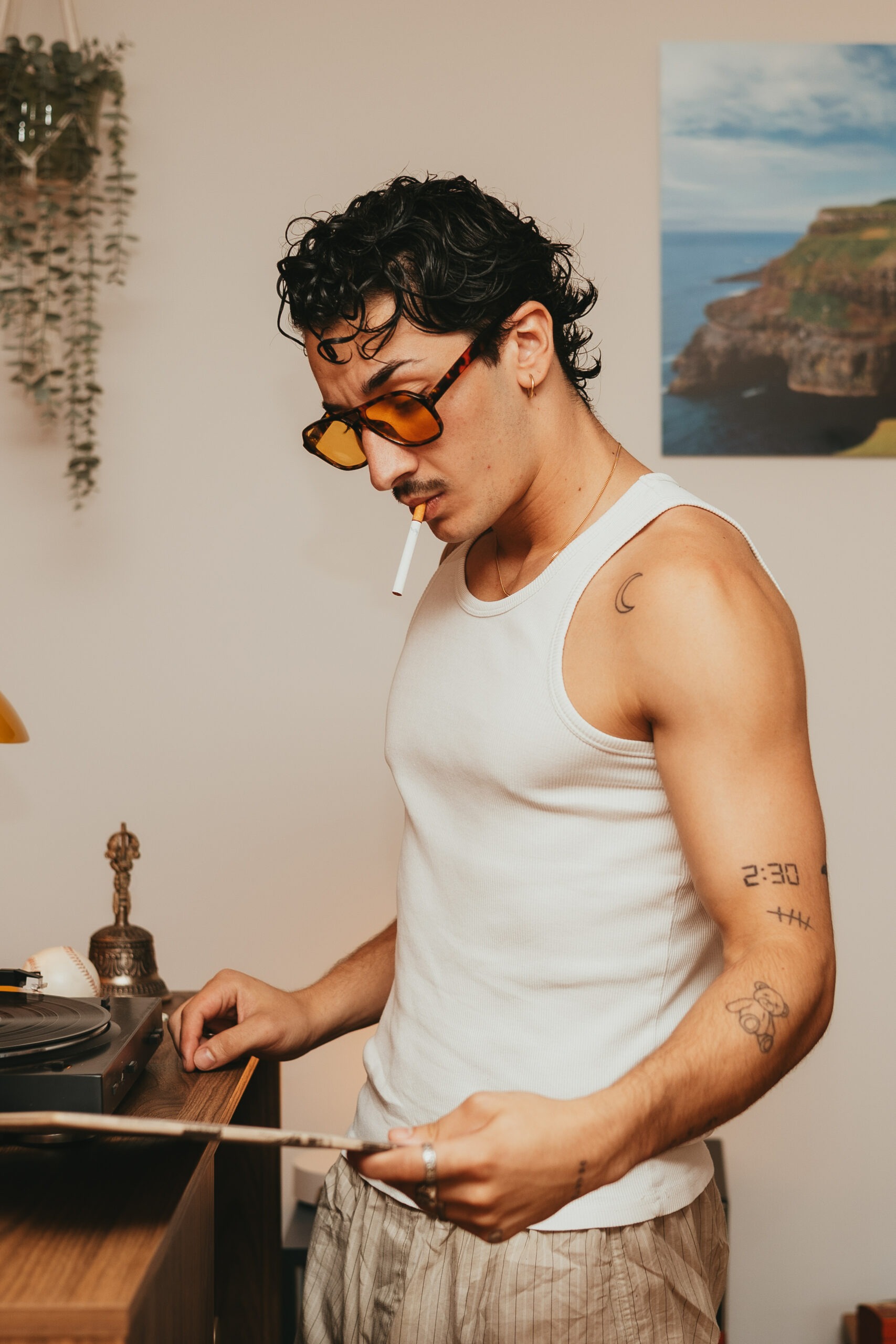 Théo choisissant un vinyle sur une platine rétro