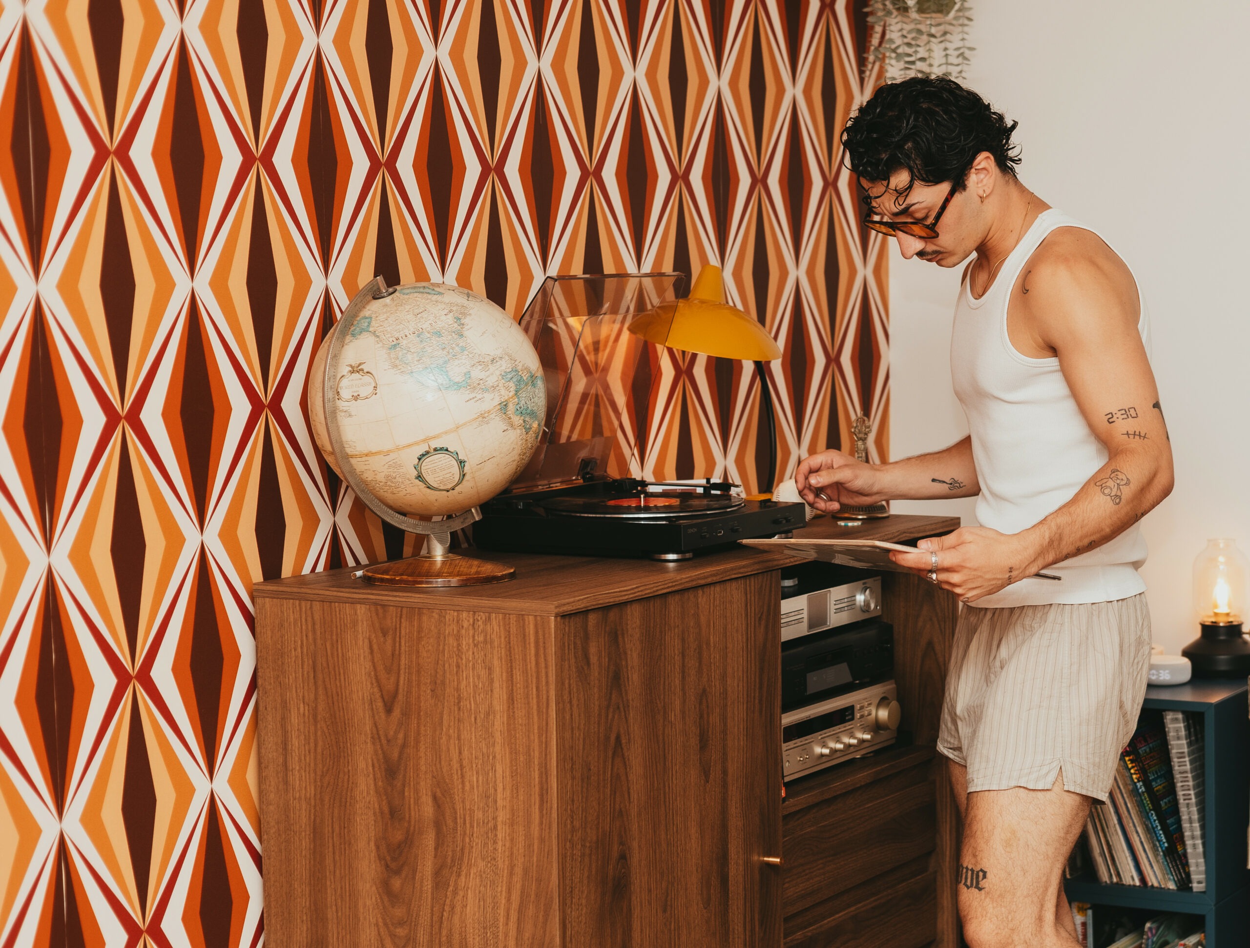Théo près d'une platine vinyle et d'un globe terrestre vintage