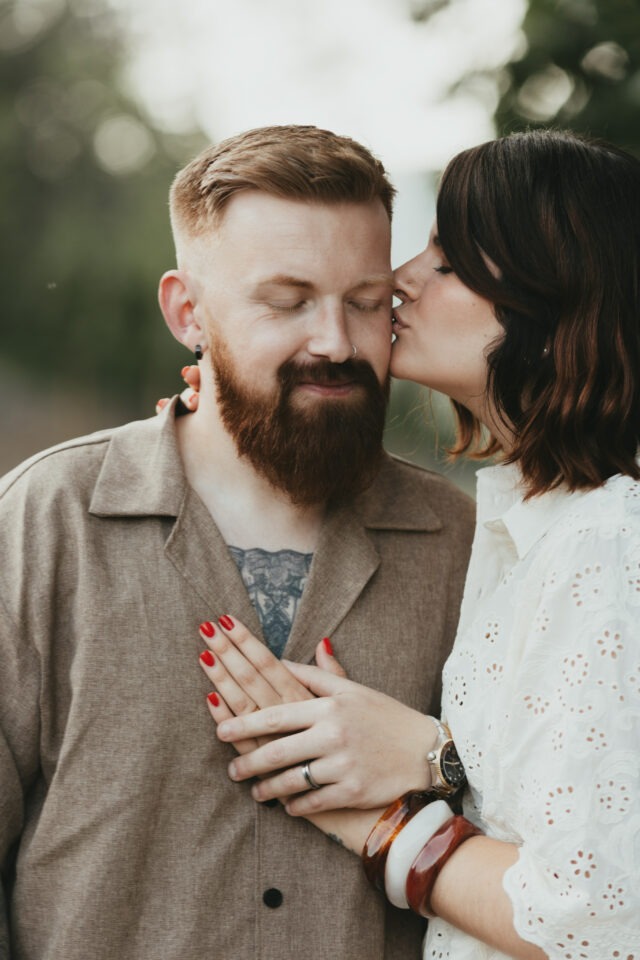 Couple tendre, elle l'embrassant sur la tempe, la main posée sur son cœur