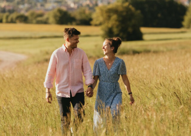 Couple se tenant la main en marchant dans les hautes herbes en Alsace