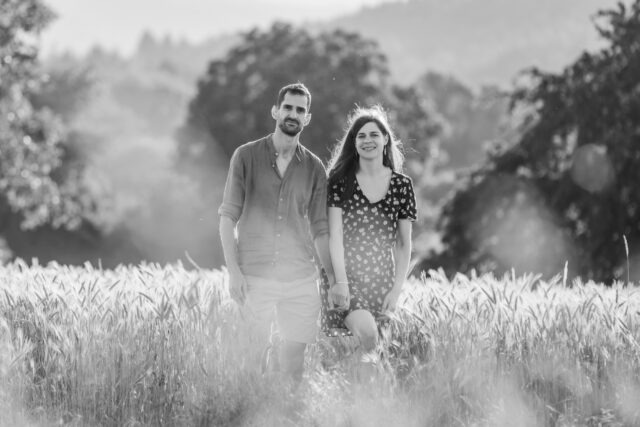 Couple marchant main dans la main dans un champ de blé, photo en noir et blanc
