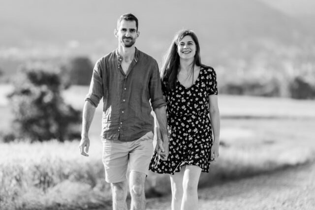Couple souriant marchant main dans la main, photo en noir et blanc