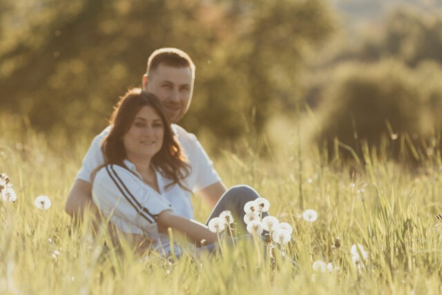 Couple assis dans un champ de fleurs sauvages, moment complice en Alsace